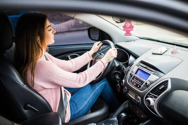 Portrait of beautiful happy woman driving a car in city street — Stock Photo, Image