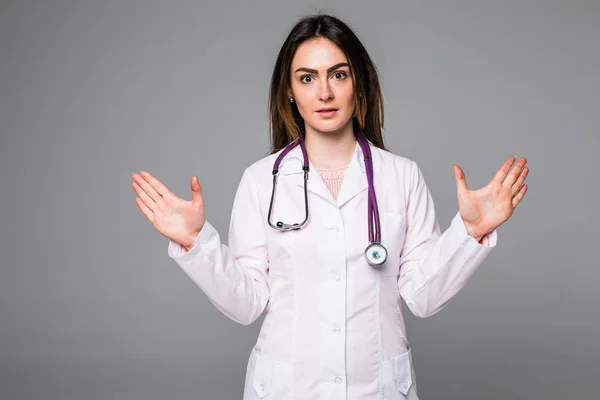 Leende glada läkare pekar med upphöjda händer på grå bakgrund — Stockfoto