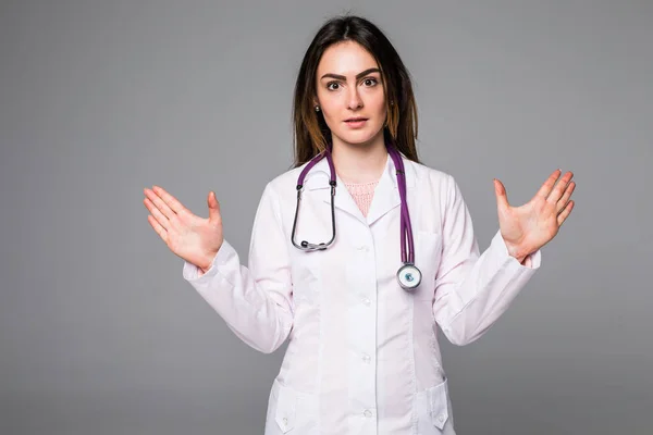 Sonriente médico feliz señalando con las manos levantadas sobre fondo gris — Foto de Stock