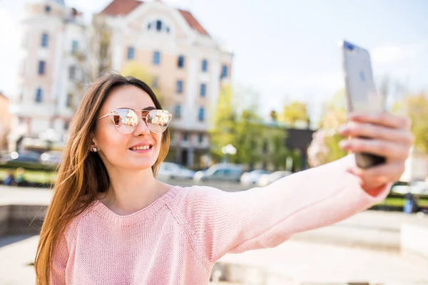 Fiatal lány szelfit csinál a kezéből telefonnal a Summer City Streeten. A városi élet fogalma. — Stock Fotó