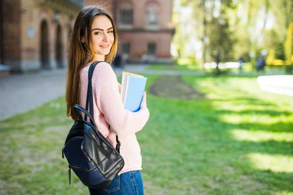 Estudante universitário sorrindo com café e saco de livro no campus com espaço de impressão — Fotografia de Stock