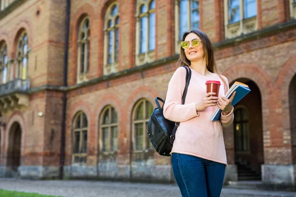 Estudante sorrindo com saco e tirar café no jardim do campus — Fotografia de Stock