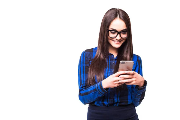 Bela jovem empresária segurando telefone celular e digitando enquanto está de pé contra fundo branco — Fotografia de Stock