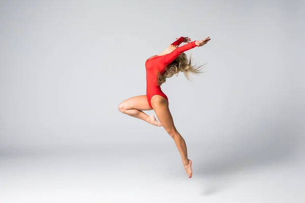 Mladé krásné tanečnice gymnastické pózuje na studio pozadí — Stock fotografie