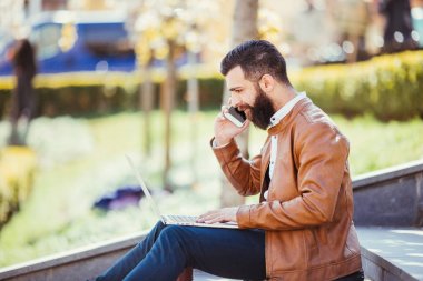 Telefonda konuşurken merdivenlerden onun laptop yanında oturan hipster yakışıklı genç adam