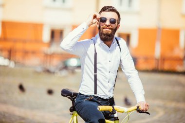 Yakışıklı hipster şehir binmek bisiklet tarafından zevk güneş gözlüğü.