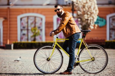 Sakallı yakışıklı genç güneş gözlüğü şehirde bisiklet. Bisiklet kavramı