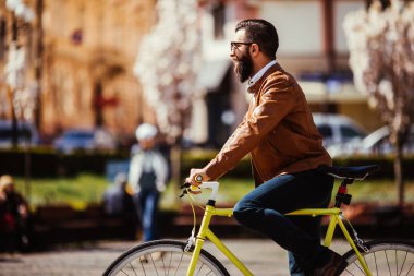 Genç adam güneşli Caddesi üzerinde açık havada bisiklet sürme sakallı