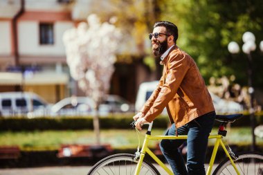 Genç adam güneşli Caddesi üzerinde açık havada bisiklet sürme sakallı