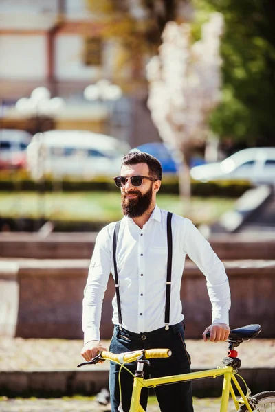 Молодой стильный бородатый мужчина с велосипедом на солнечной улице — стоковое фото