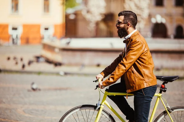 Hipster homem andando em uma bicicleta fixie nas ruas ensolaradas da cidade . — Fotografia de Stock