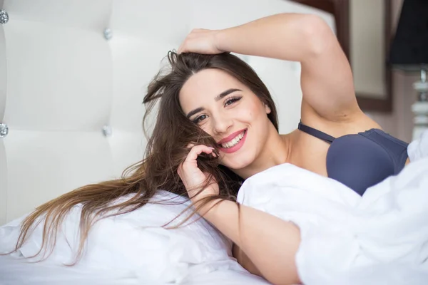 여자 아름다움 미소 홈에 흰색 침대에 누워 — 스톡 사진