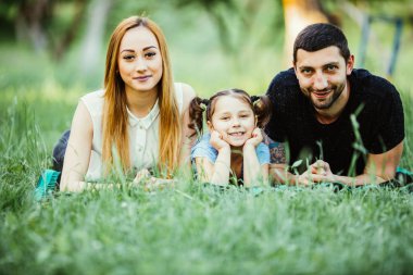 Üç çim üzerinde yalan mutlu aile. mutlu aile ilişkileri ve kaygısız boş zaman kavramını