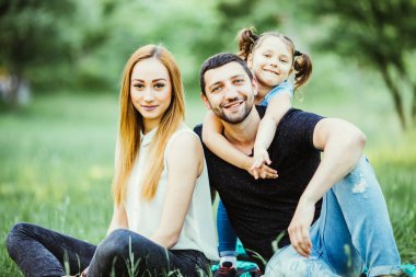 Mutlu bir genç aile yaz günü dışarıda vakit geçirir.