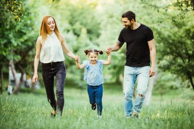 mutlu anne, baba ve küçük kız birlikte çalışan ve yaz park eğlenmek