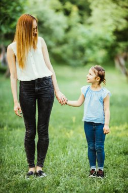 Anne ve kızı parkta eğleniyor. Mutlu aile kavramı. Aile hayatı olan güzel doğa manzarası. Mutlu bir aile birlikte dinleniyor. Aile hayatında mutluluk ve uyum..