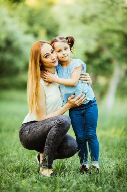 Anne ve kızı parkta eğleniyor. Mutlu aile kavramı. Aile hayatı olan güzel doğa manzarası. Mutlu bir aile birlikte dinleniyor. Aile hayatında mutluluk ve uyum..