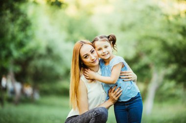 Anne ve kızı parkta eğleniyor. Mutlu aile kavramı. Aile hayatı olan güzel doğa manzarası. Mutlu bir aile birlikte dinleniyor. Aile hayatında mutluluk ve uyum..