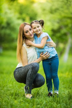 Anne ve kızı parkta eğleniyor. Mutlu aile kavramı. Aile hayatı olan güzel doğa manzarası. Mutlu bir aile birlikte dinleniyor. Aile hayatında mutluluk ve uyum..
