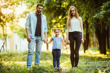 Anne, baba ve küçük kız yaz Park'ta yürüyordunuz ve having fun