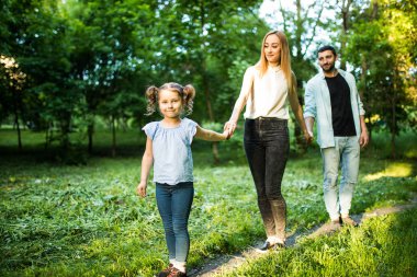 Genç aile yaz Park'ta yürüyordunuz dikiz