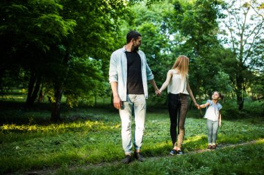 mutlu anne, baba ve küçük kız yaz Park'ta yürüyordunuz ve having fun