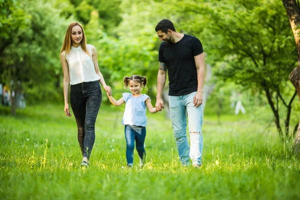 Joyeux jeune famille marchant dans le parc. Concept de mode de vie sain — Photo