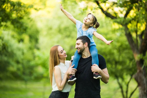 Père, mère et jeune fille sur le dos avec les mains levées comme voler sur fond de parc d'été — Photo