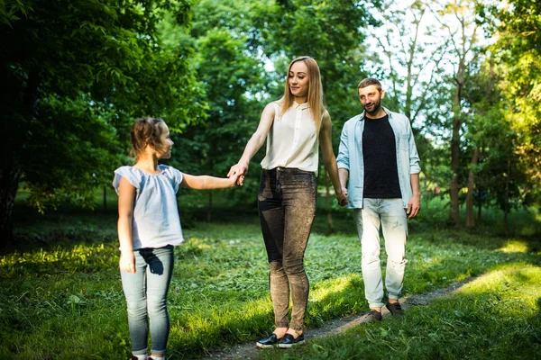 Vista trasera de la familia joven caminando en el parque de verano — Foto de Stock
