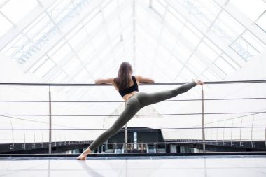 Güzel yoga kadın pratik bir büyük iş salonu arka planda. Yoga kavramı.