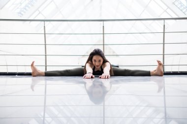 Geniş açı oturmuş ileri Bend. Spor salonunda egzersiz çekici genç fitness modeli