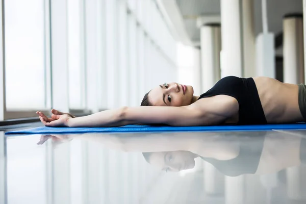 Joven hermosa mujer practicando yoga con ventanas panorámicas en el fondo. Concepto de libertad. Tranquilidad y relax, felicidad de la mujer . — Foto de Stock