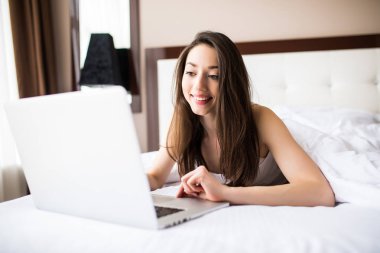 Gülümseyen ve o onu laptop ile kredi kartını kullanır onun önünde seyir kadın.