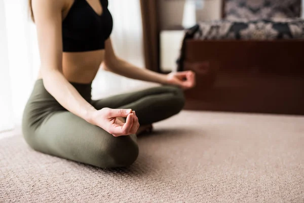 Evde yoga. Lotus pozisyon katta oturan gözleri kapalı çekici genç kadın. — Stok fotoğraf