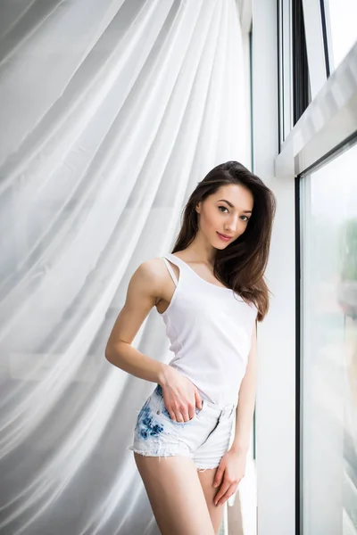 Крупним планом щаслива жінка відкриває віконні штори вранці — стокове фото