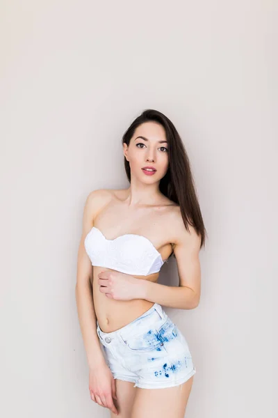 Beautiful woman wearing jeans shorts and bra isolated — Stock Photo, Image