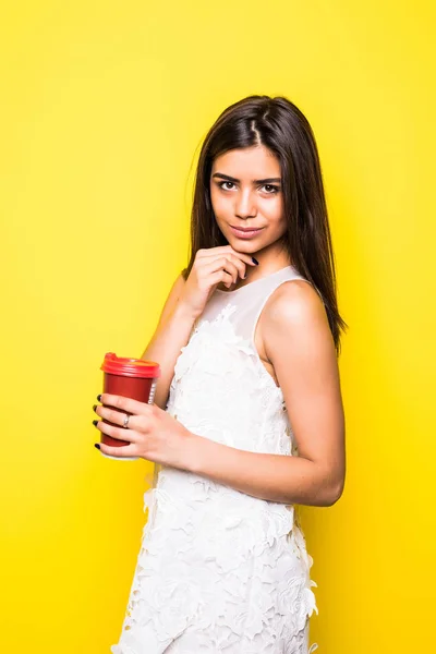 Mladá městské příležitostné žena pití kávy ve žlutém pozadí — Stock fotografie