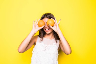 Sarı arka plan üzerinde taç ve güzel elbise giyen güzel genç kadın