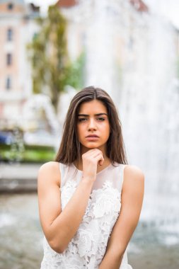 Çeşme yakınındaki genç beyaz kadın ayakta. Yakın çekim portre kadın açık.