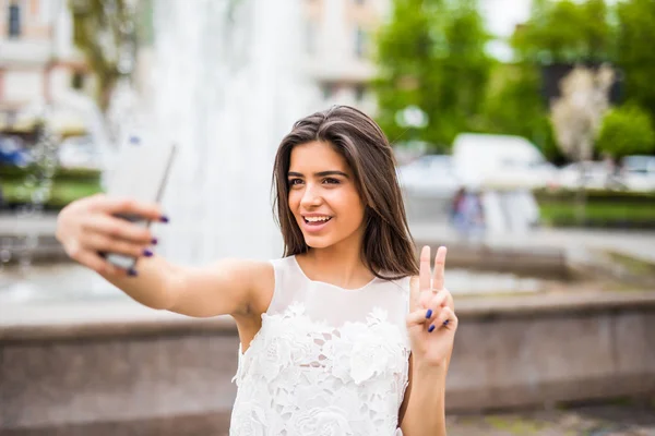 Ragazza allegra facendo foto selfe e mostrando la vittoria — Foto Stock