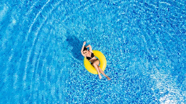 Concetto di vacanza. Vista dall'alto della giovane donna magra in bikini sull'anello gonfiabile ad aria gialla nella grande piscina . — Foto Stock