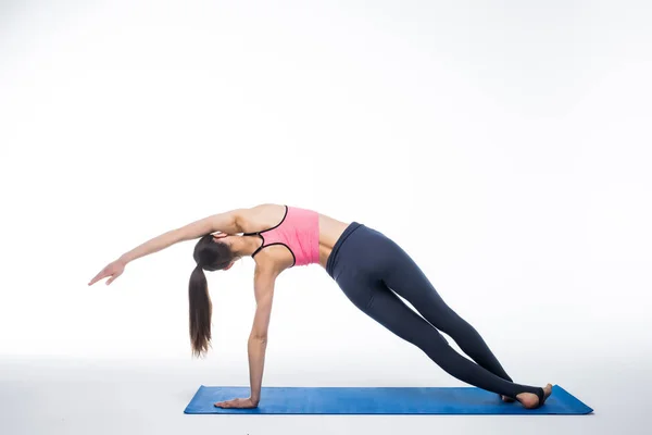 Jeune femme yoga posant sur fond blanc isolé studio — Photo