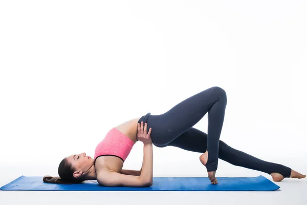 Mujer joven deportiva haciendo práctica de yoga aislada sobre fondo blanco —  Fotos de Stock