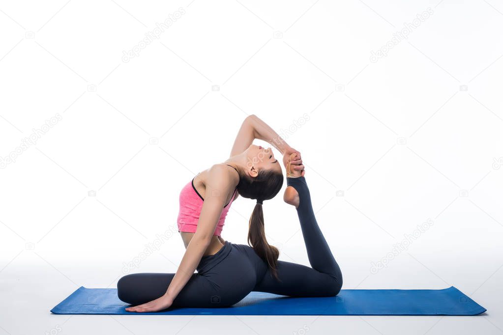 young beautiful woman yoga posing on isolated white studio background