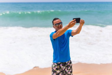 Tatilde plajda selfie alarak gülerek mutlu gülümseyen yakışıklı 