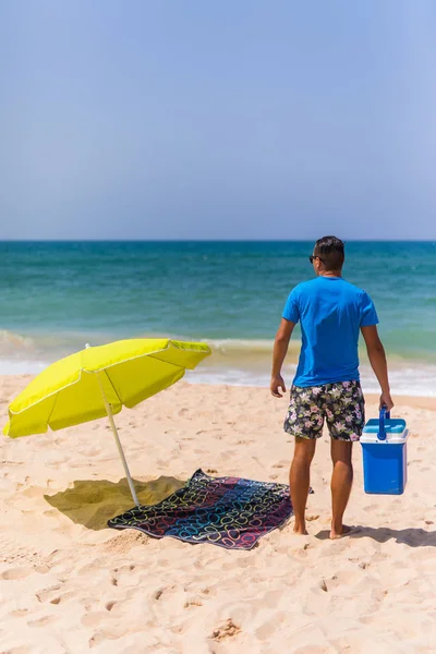 Νεαρός άνδρας με μπαρ πάγου cooler υπό ηλιακή ομπρέλα παραλίας ΒΑ — Φωτογραφία Αρχείου