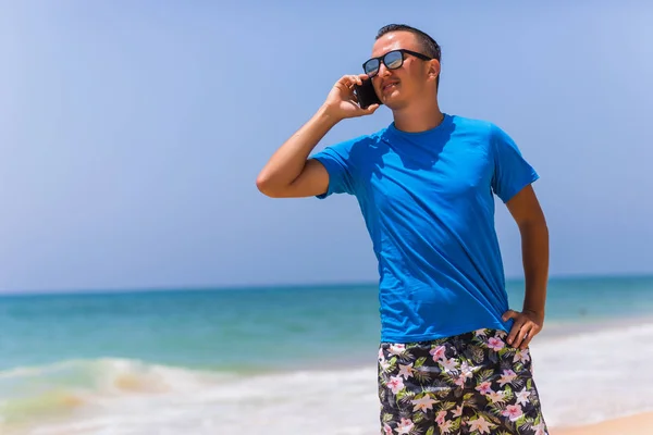 Jovem falando por telefone na praia — Fotografia de Stock