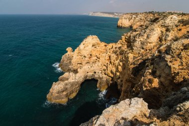 Güzel Atlantik Okyanusu görünümü ufuk kumlu plaj kayalar ve gündoğumu algarve dalgaları