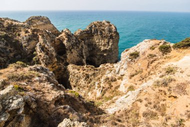 Güzel Atlantik Okyanusu görünümü ufuk kumlu plaj kayalar ve gündoğumu algarve dalgaları