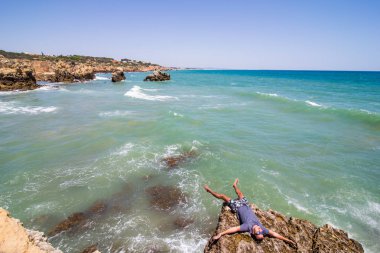 Kayalar uçuruma okyanus algarve Portekiz üzerinde yatan genç adam. Yaz meslek kavramı